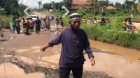 Kado HUT Lamtim, Warga Tabur Ikan di Jalan Rusak